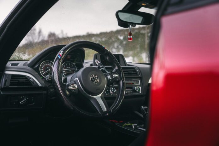 Interior view of a red car's steering wheel